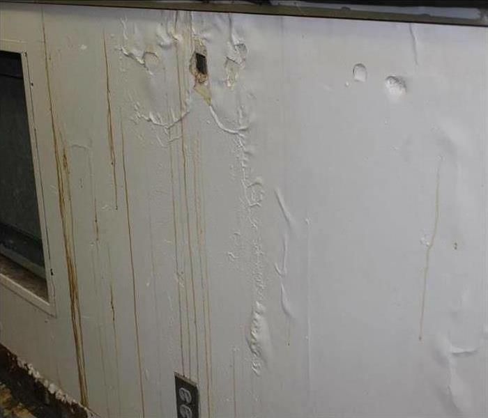 Water damage behind paint on wall.